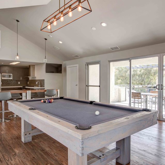 Stoneridge – Modern clubhouse interior featuring a sleek gray pool table at the center