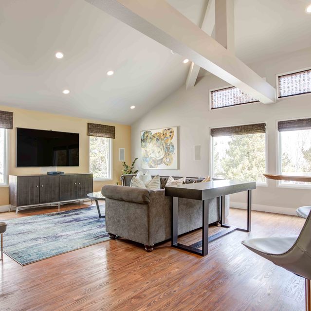 Stoneridge – Spacious living area with vaulted ceilings and exposed beams, featuring a large wall-mounted TV