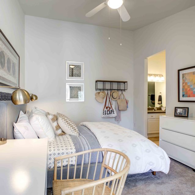 Stoneridge – Cozy bedroom with a neatly made bed featuring patterned bedding and an upholstered headboard